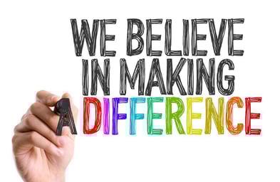 Hand with marker writing We Believe in Making a Difference